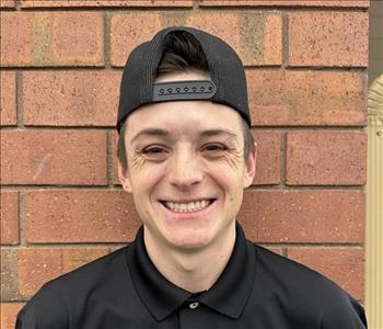 smiling man with backwards hat and short brown hair