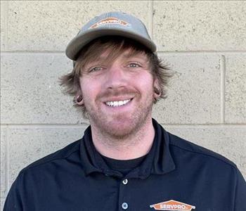 Smiling man with dirty blond hair and serv pro hat