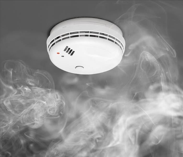 Image of a smoke detector with smoke around it