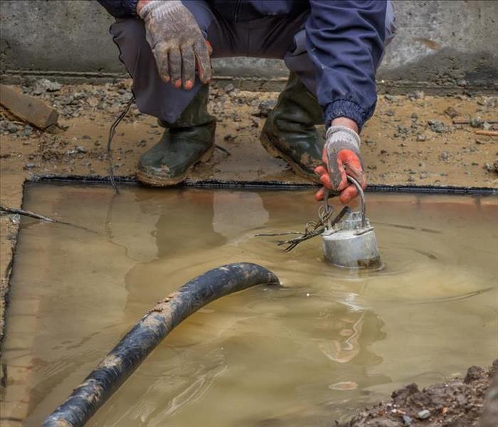 Image of a person pumping water from a construction site.
