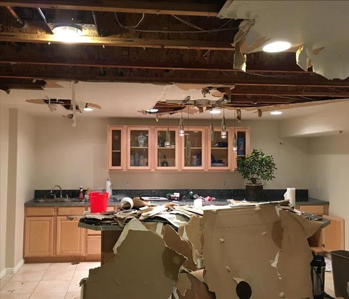 Kitchen ceiling insulation colapses after holding water due to a bursting pipe.
