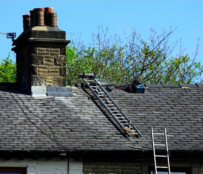 Tools and ladders where the professional is inspecting the conditions of the roof and chimney.